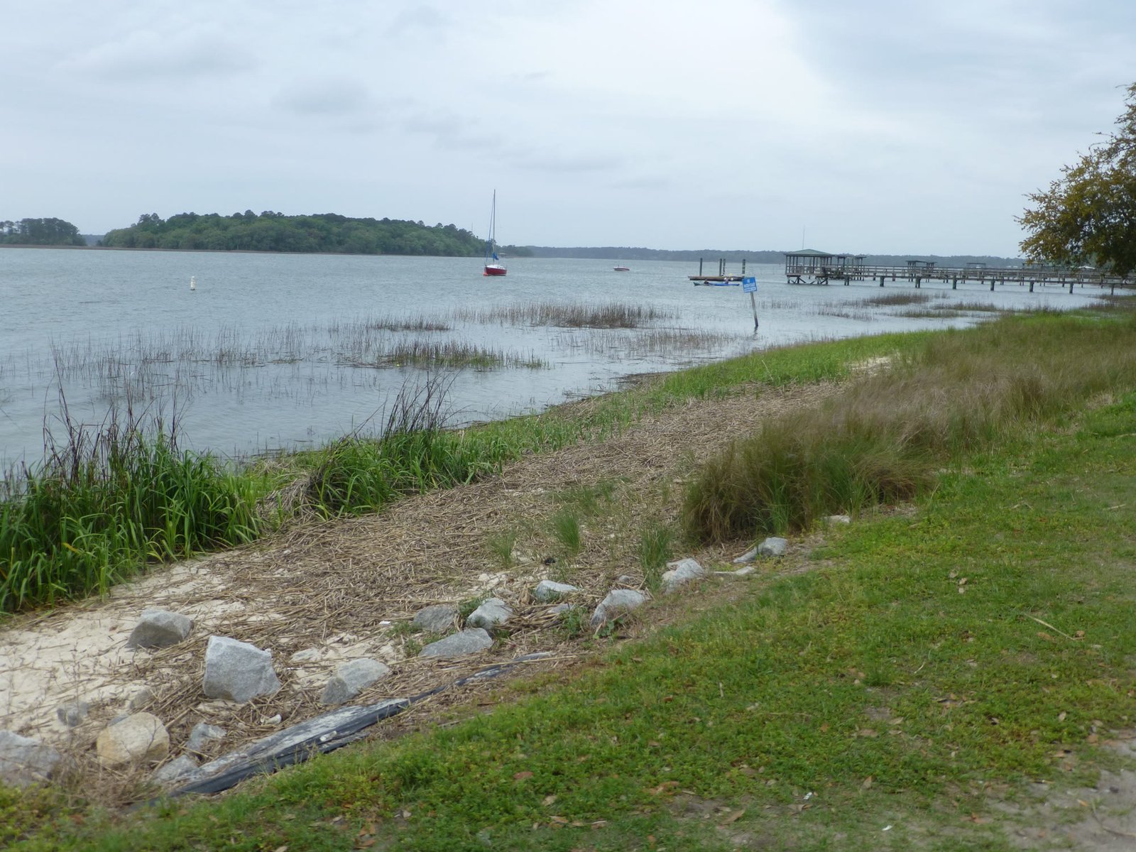 Lowcountry shoreline with a pier and sailboat in Beaufort County, South Carolina
